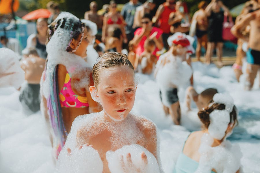 Kid covered in foam smiling at a FunLawn foam party