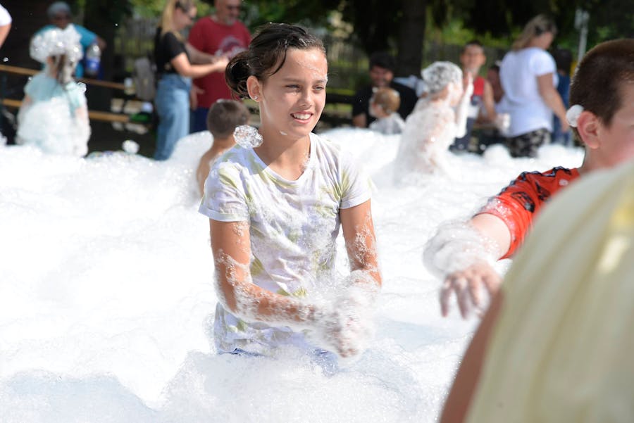Girl laughing in white foam outdoors