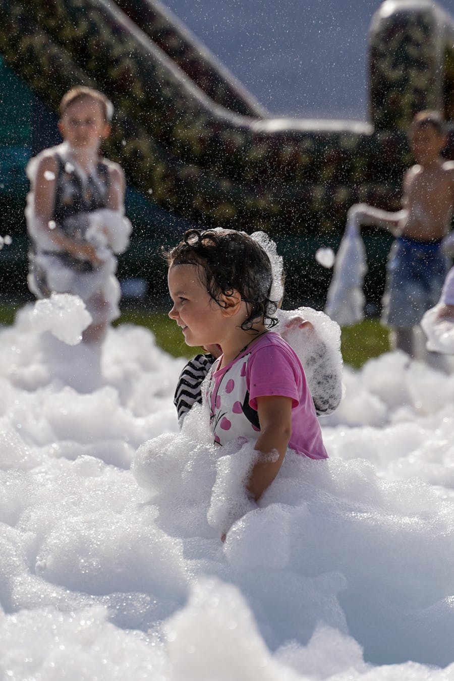 Toddler playing in foam at a kids foam party